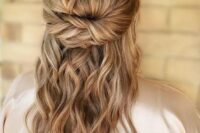 a twisted half updo with a bump on top and waves down is a cool idea for both a bride or a bridesmaid