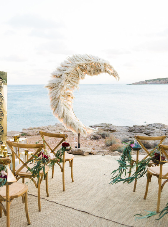 The wedding space was done with chairs with floral terrariums and a jaw-dropping pampas grass wedding altar shaped as a crescent moon
