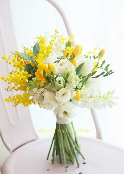 a pretty bouquet with white ranunculus, white and yellow freesia and yellow mimosa