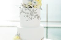 02 a white wedding cake with grey and yellow sugar flowers and some branches looks ethereal