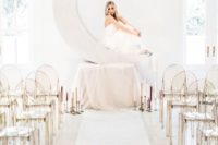 03 a cool creamy crescent moon wedding backdrop plus candles and translucent chairs for an inspiring space
