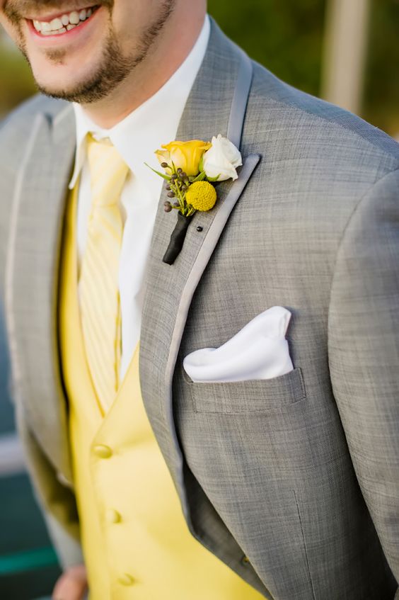 a grey suit with a yellow vest and tie is a chic groom's look for summer