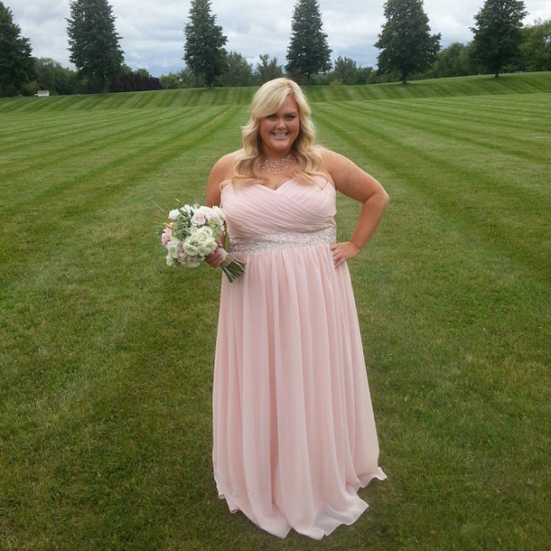 a light pink strapless maxi gown with a glitter sash and a statement necklace