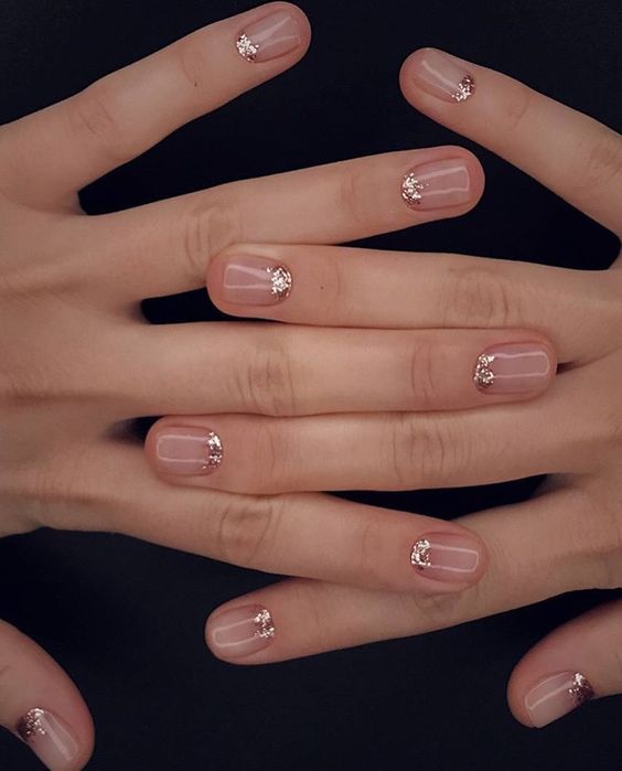 nude nails with rose gold glitter touches at the base of the nails
