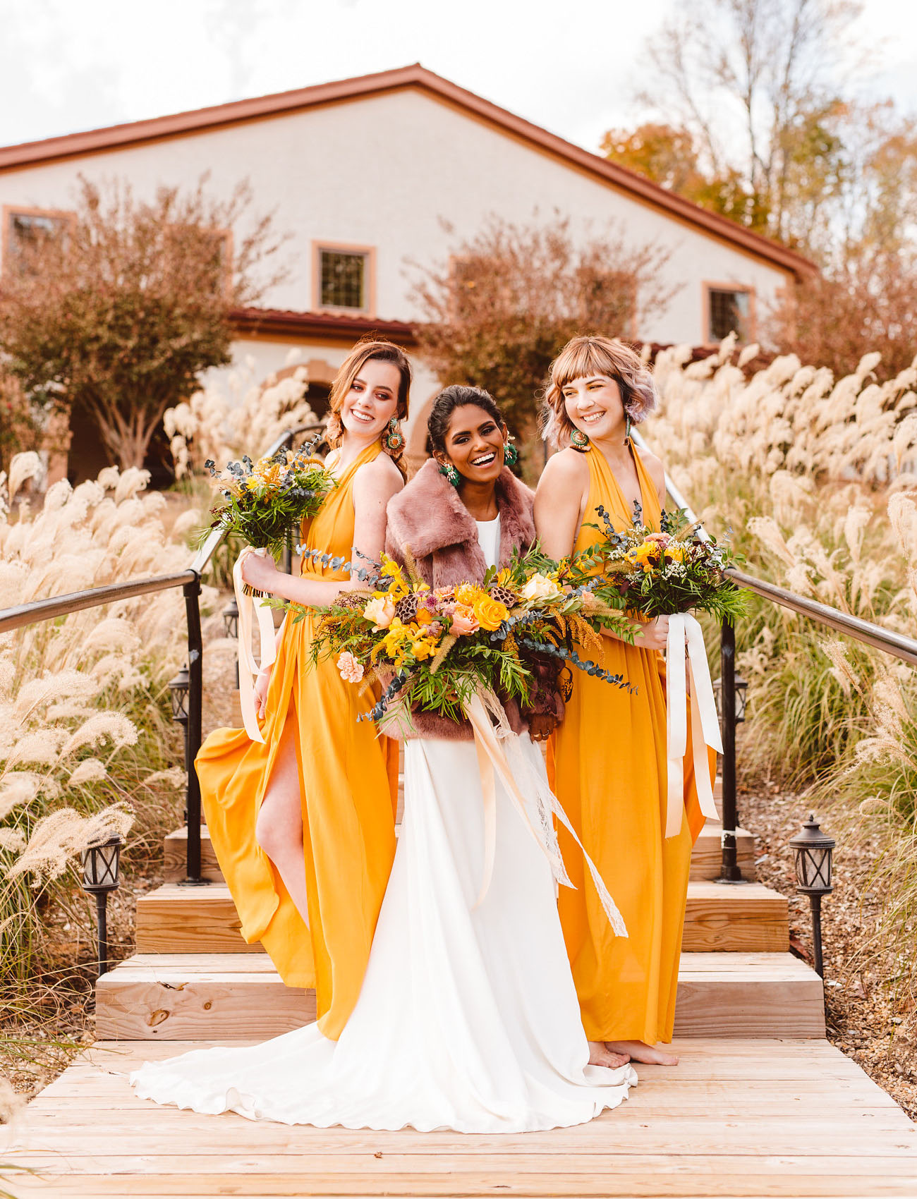 The bridesmaids were wearing chic mustard yellow maxi dresses with slits and statement earrings