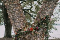 04 a tree covered with lights and with a greenery and floral garland for a wedding backdrop