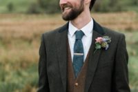 05 a dark grey three-piece suit with a brown vest, a graphite grey tie and a floral boutonniere