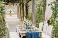 05 a refined reception space in the garden with climbing greenery and a blue table runner
