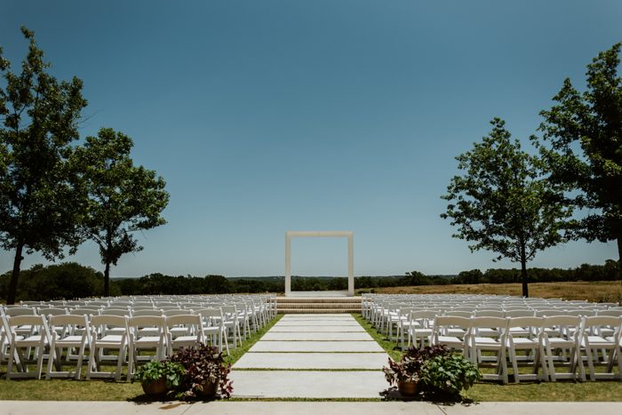 The wedding ceremony space was done with white chairs and a large frame instead of a usual floral arch