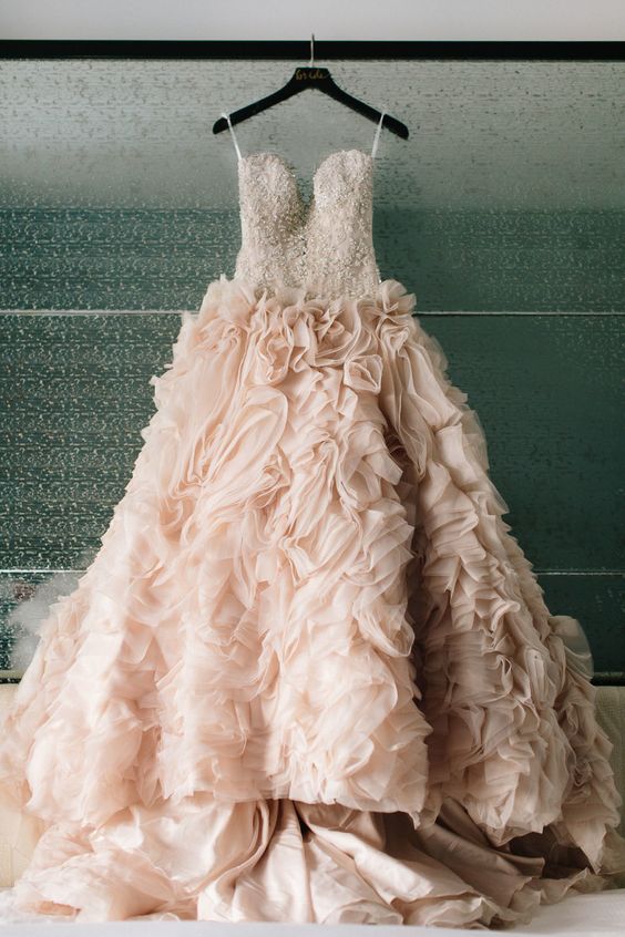 a breathtaking strapless wedding dress with a heavily embellished bodice, a ruffled layered skirt and a train for a formal look