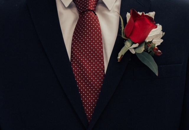 He had a printed tie and a bold red boutonniere