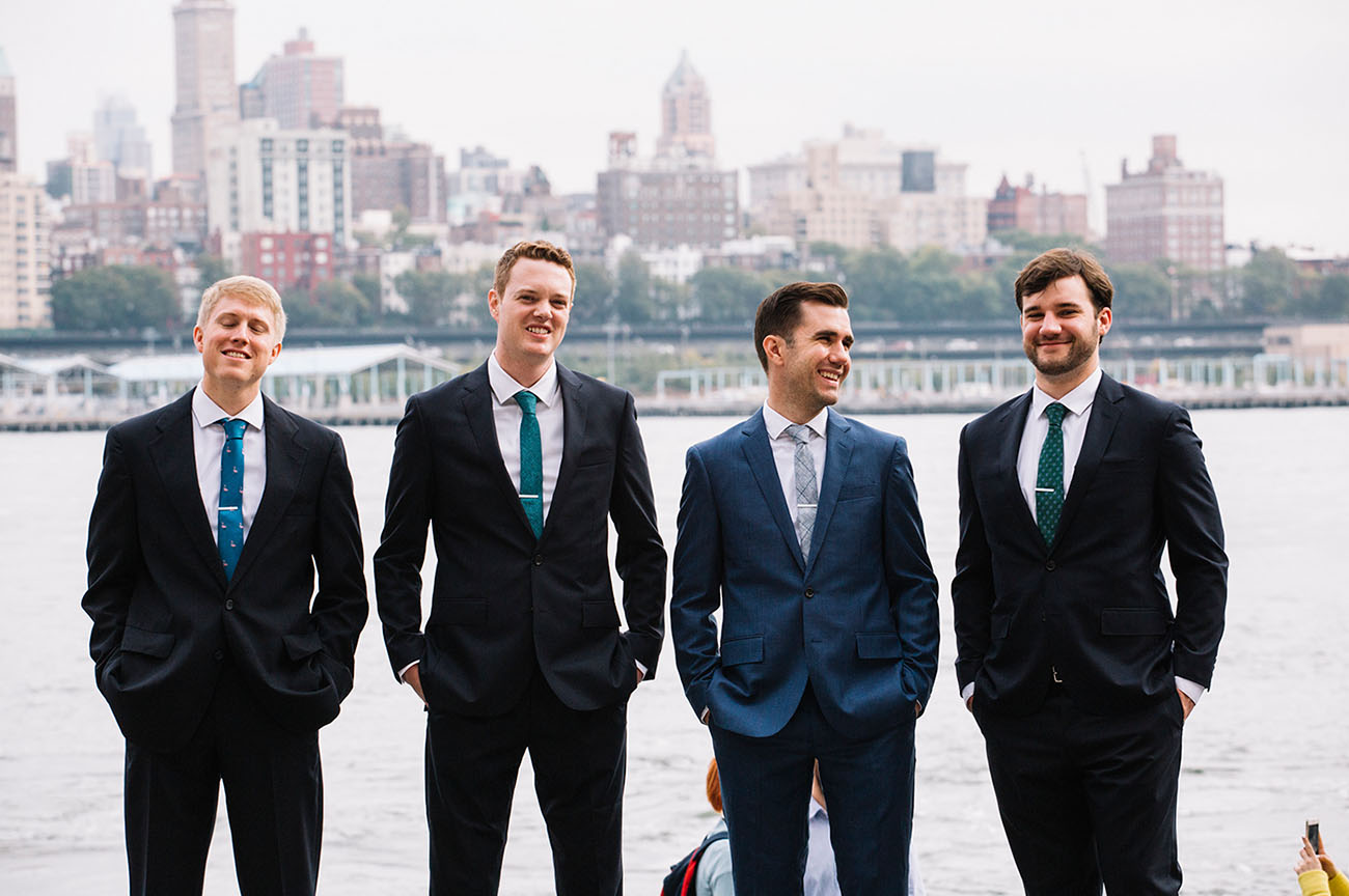 The groomsmen were wearing black suits and jewel blue and green ties