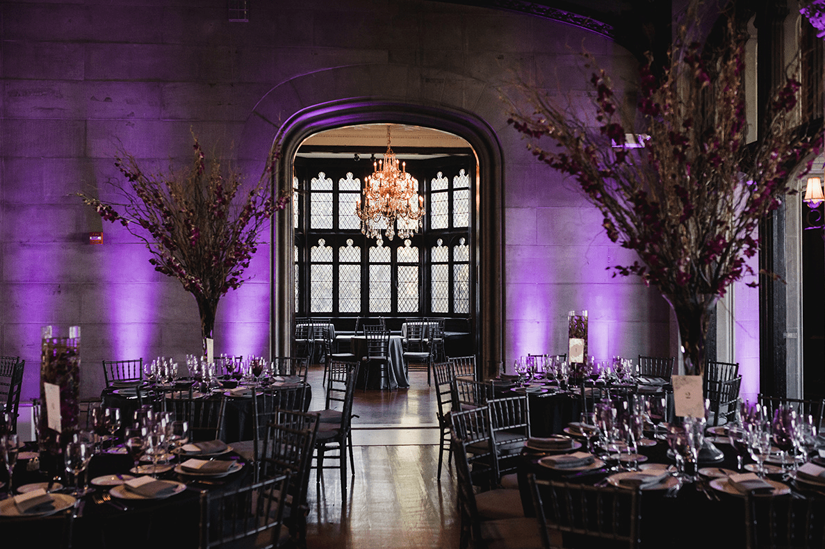 The wedding venue, which was the castle, featured gorgeous glam chandeliers, there were purple and red centerpieces and floating candles