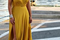 09 a mustard maxi dress with a deep V-neckline and a side slit, a small and thin leather belt