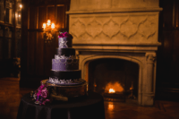 10 The wedding cake was a purple and black one, decorated with hite cream patterns and topped with purple blooms
