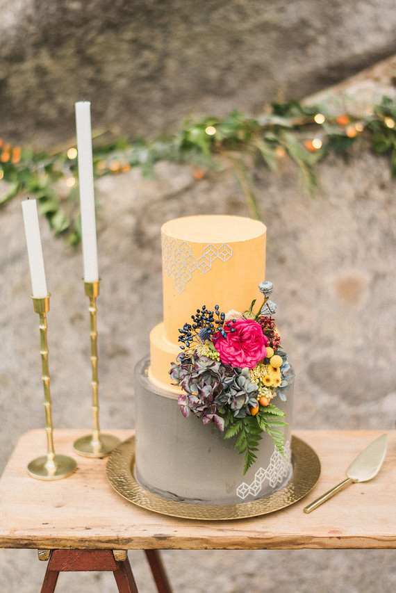 The wedding cake was done in grey and yellow and with bold blooms on the side