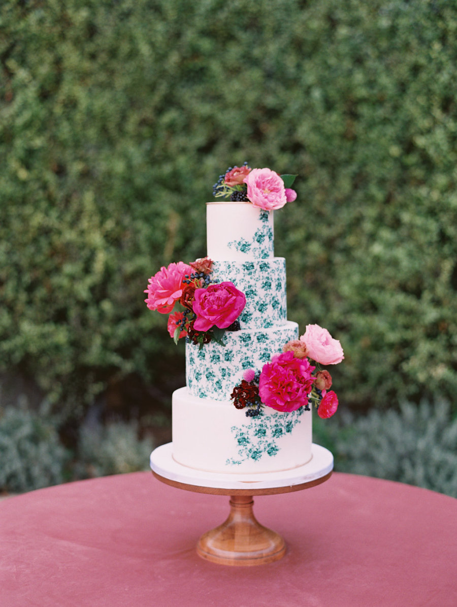 The wedding cake was half painted and decorated with the same fuchsia and pink florals