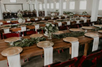 10 The wedding venue was doen with simple uncovered wooden tables, greenery runners and greenery and white bloom centerpieces