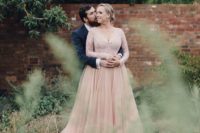 10 a dusty pink wedding dress with a pleated skirt and an embellished bodice with long sleeves