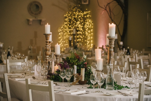 The tables were done with textural greenery and flower centerpieces and candles in vintage candle holders
