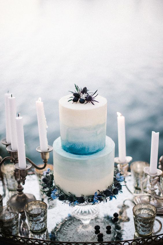 buttercream is ideal for decorating the cake with watercolor, here an ombre blue wedding cake with blueberries and thistles