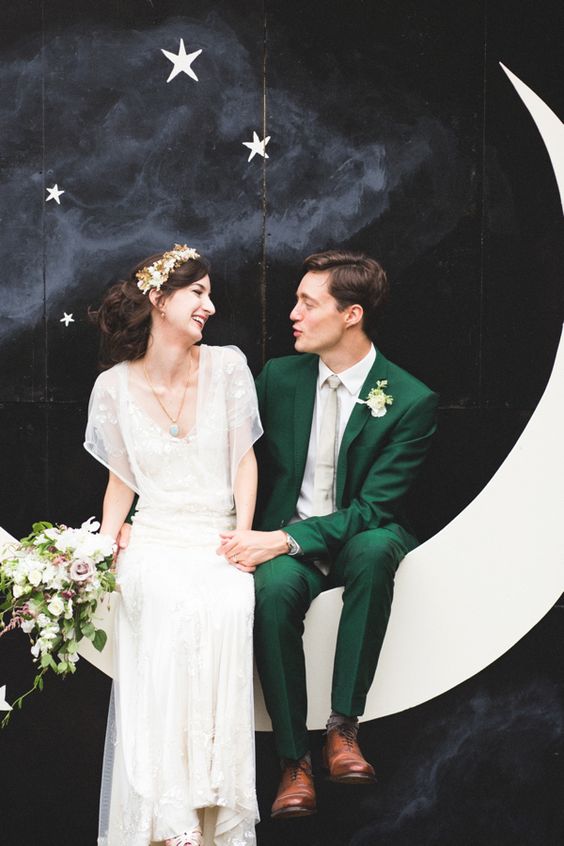 a black night sky with stars and a crescent moon wedding photo booth backdrop for a vintage feel