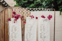 12 a boho woven seating chart with bold pink blooms on a copper frame for a colorful touch
