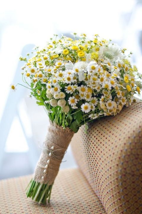 a rustic bridal bouquet of wildflowers and with a burlap wrap with pearl pins