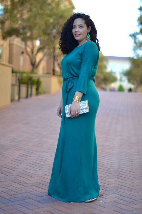 an emerald high neckline long sleeve bridesmaid's dress with matching earrings and a metallic clutch