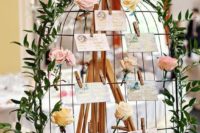 13 a chic birdcage-styled seating chart with fresh roses, greenery and floral escort cards attached