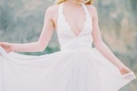 13 a chic wedding dress with thick halter straps, a lace bodice with a deep neckline and a bandage detail plus a flowy skirt