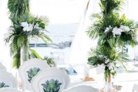 14 a tropical beach wedding ceremony with lush tropical leaves and white orchids