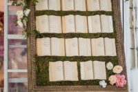 16 a framed moss wall with lush blooms and greenery and vintage books where you can see the places
