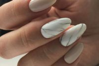 16 creamy nails and a couple of white marble accent nails for a chic and bold touch
