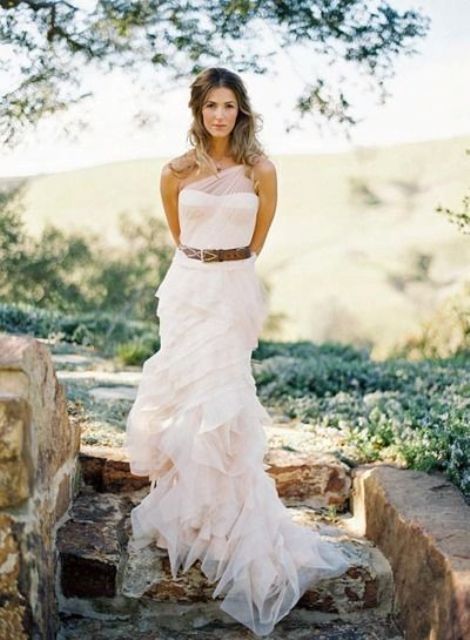 a lovely blush wedding gown accented with a brown leather belt for a light rustic feel