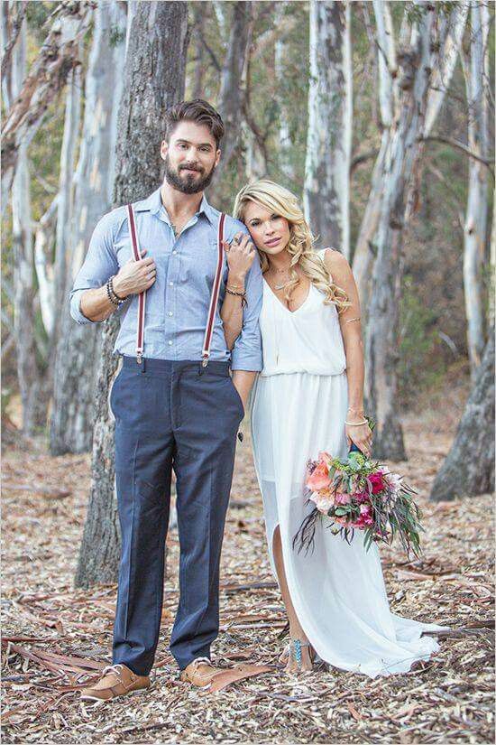 a rustic vintage groom outfit with a chambray shirt, navy pants, brown shoes, striped suspenders