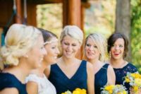 18 bridesmaids in navy dresses and holding yellow bouquets is a very bold and chic combo to go for