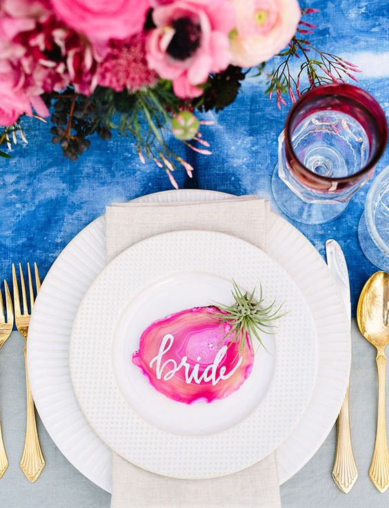 a bold blue watercolor table runner, a bright pink floral centerpiece and an agate slice card