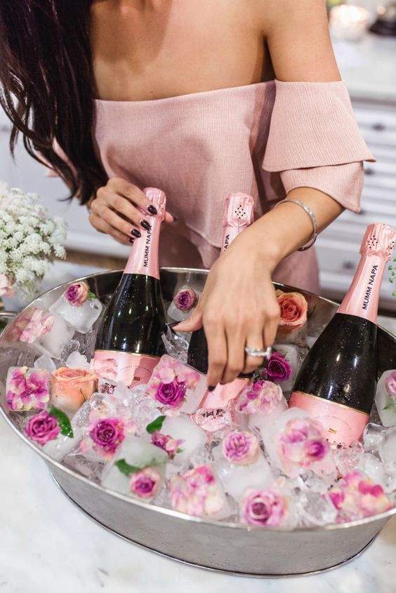 a galvanized tray with florla ice cubes and pink champagne for a glam party