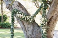 20 a large double tree with a luxurious greenery and white bloom garland for decor