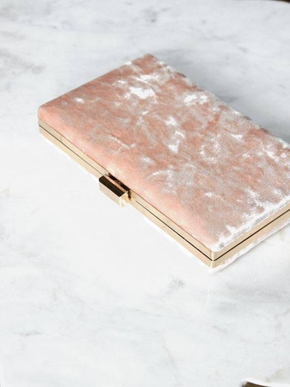a light pink velvet clutch with gold framing is a trendy idea and a great piece to rock after the wedding