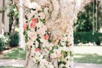 21 a large tree covered with ivory and coral flowers and with hanging crystals for a glam feel