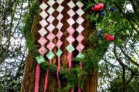 21 a moss and greenery covered wreath with bold blooms and ombre escort cards is a nice idea for a woodland fete