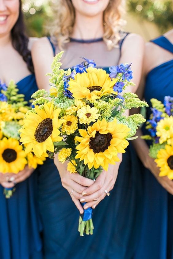 navy dresses and sunflower and delphinum bridesmaids' bouquets for an elegant combo