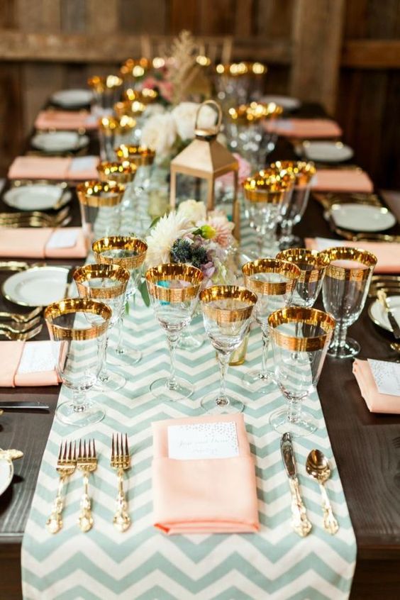 a chevron mint table runner, peachy napkins and gold flatware and gold rimmer glasses