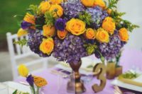 23 a purple tablecloth, yellow napkins, a bold centerpiece of purple hydrangeas and yellow roses for an exquisite look