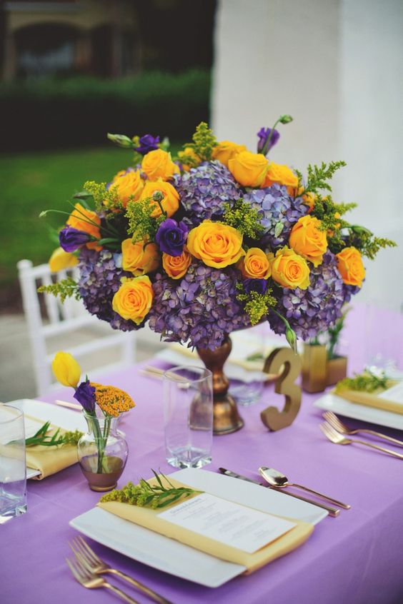 a purple tablecloth, yellow napkins, a bold centerpiece of purple hydrangeas and yellow roses for an exquisite look