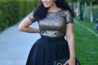 23 an ensemble of a dark sequin top with short sleeves and a full black A-line skirt