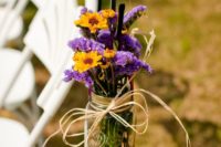 24 a mason jar with purple and yellow blooms plus twine for wedding aisle decor