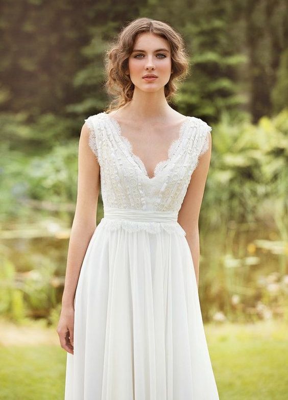 a very romantic vintage-inspired wedding dress with thick straps and a lace bodice and straps plus a flowy skirt